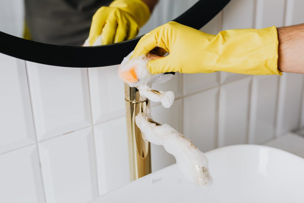 person washing faucet in bathroom